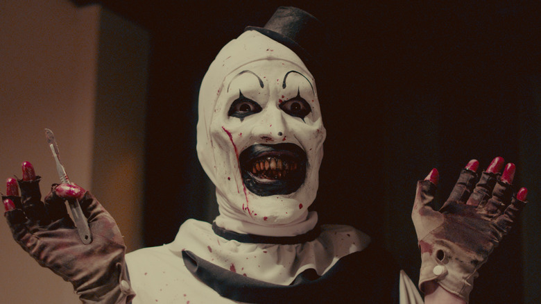 David Howard Thornton as Art the Clown smiling in Terrifier