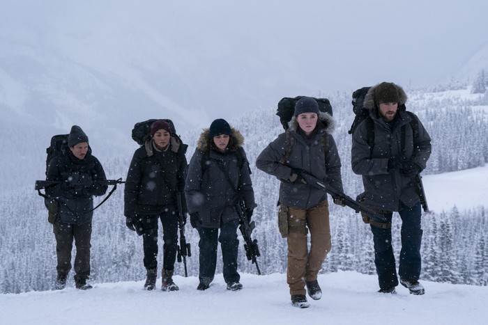 The Last of Us Danny Ramirez as Manny, Tati Gabrielle as Nora, Ariela Barer as Mel, Kaitlyn Dever as Abby and Spencer Lord as Owen in The Last of Us, walking through the snow holding guns