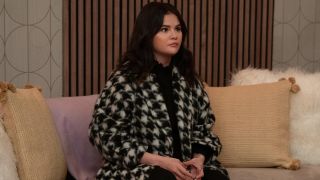 Selena Gomez in Season 3 of Only Murders in the Building sitting on a couch.